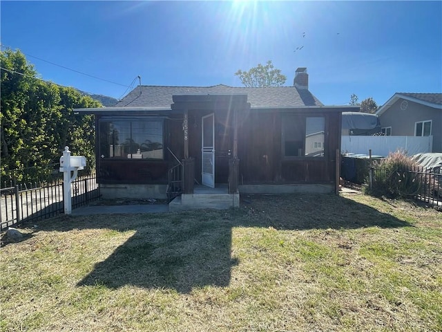 back of property featuring a sunroom and a yard