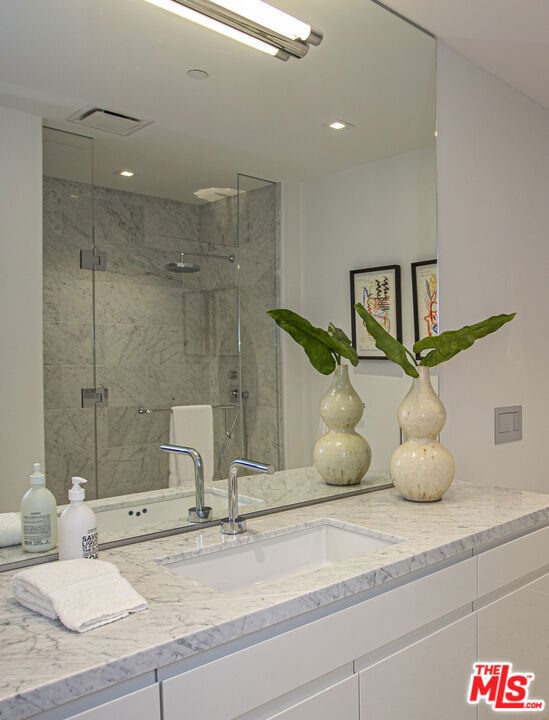 bathroom featuring vanity and a shower with shower door