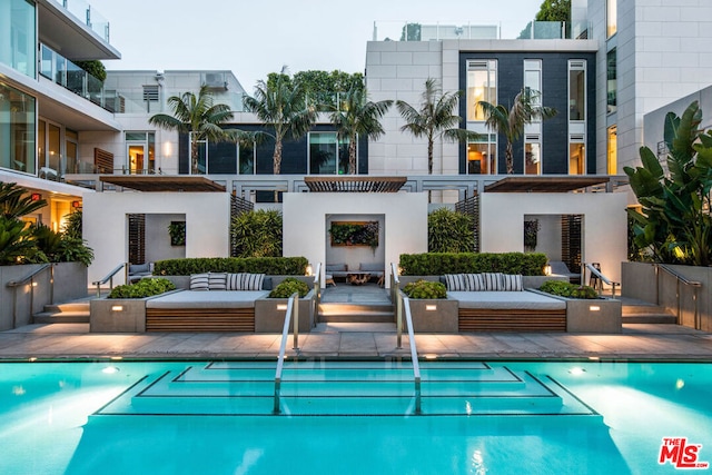 view of swimming pool featuring an outdoor living space with a fireplace and a patio