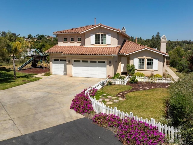 mediterranean / spanish house with a playground, a garage, and a front yard