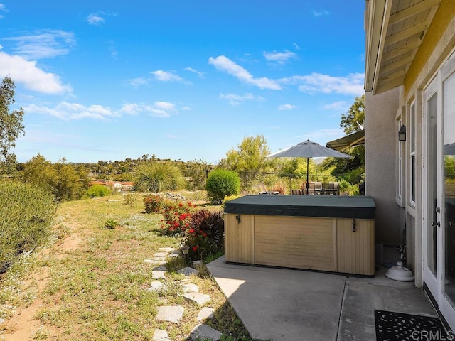 view of yard with a hot tub and a patio area