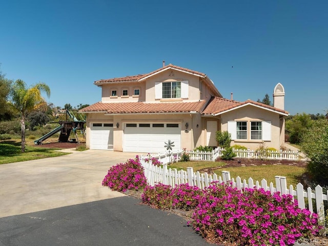 mediterranean / spanish-style house with a garage and a playground