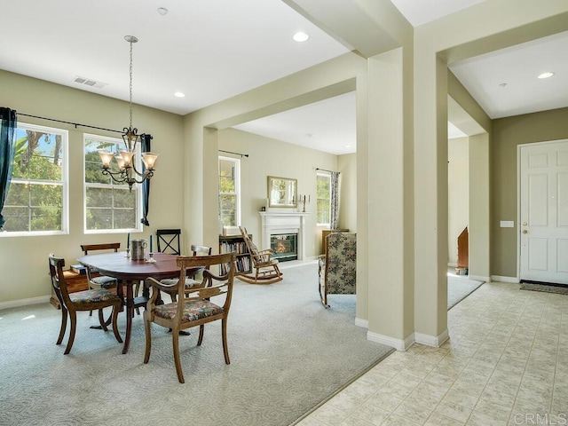 dining space featuring plenty of natural light, light carpet, and a notable chandelier