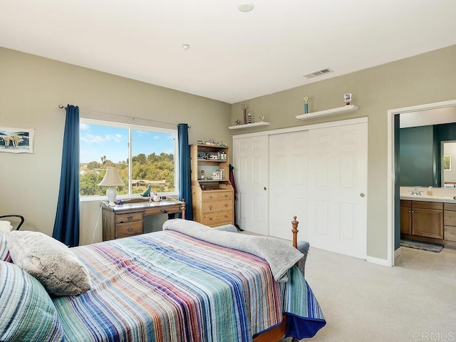 carpeted bedroom featuring sink and a closet