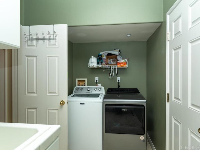 washroom with separate washer and dryer and cabinets