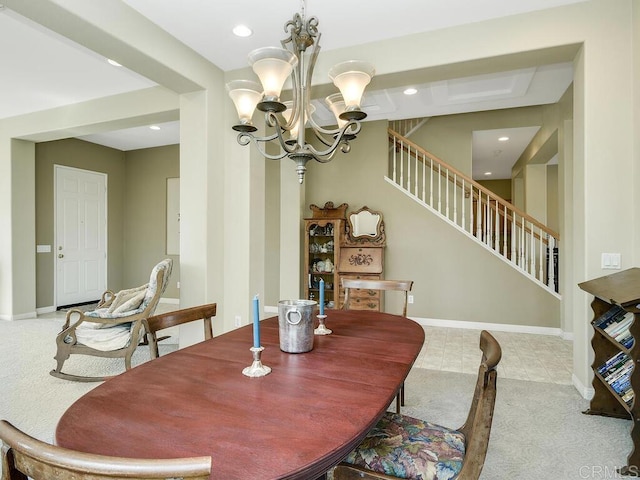 dining space featuring light carpet and a chandelier