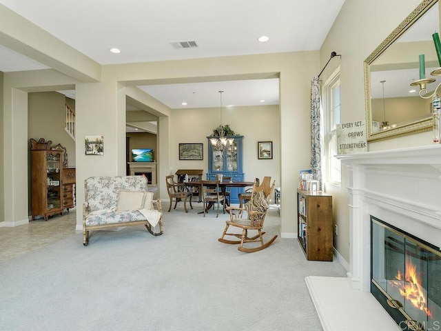 living area with light carpet and a notable chandelier