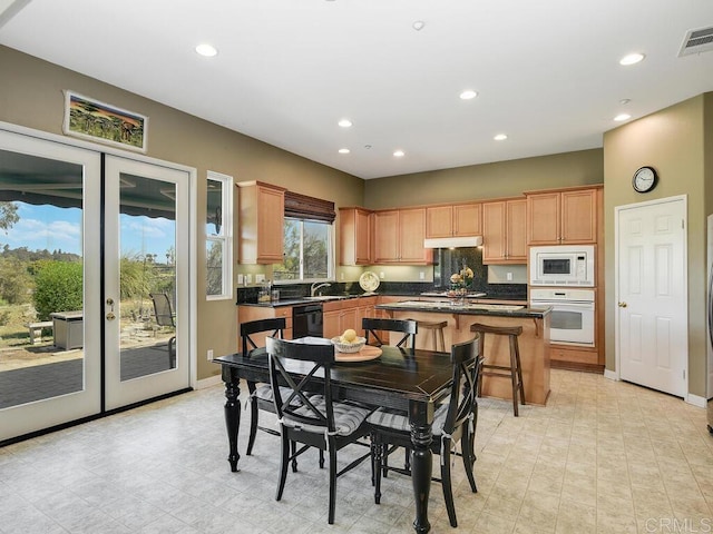 kitchen featuring french doors, white appliances, sink, and a kitchen island