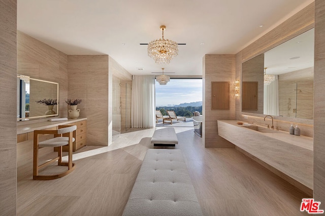 bathroom with vanity, an inviting chandelier, tile walls, and a tub