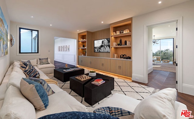 living room with built in features and light hardwood / wood-style floors