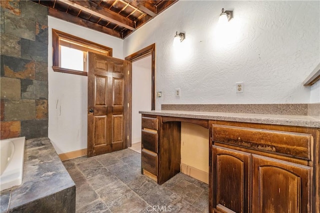 bathroom with a washtub, beam ceiling, vanity, and wood ceiling