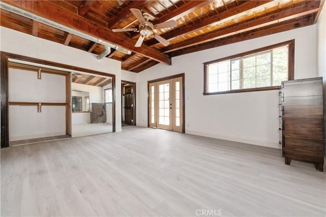 unfurnished living room featuring wood ceiling, a wealth of natural light, light hardwood / wood-style flooring, and lofted ceiling with beams