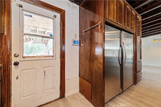 kitchen with stainless steel built in fridge and light hardwood / wood-style flooring