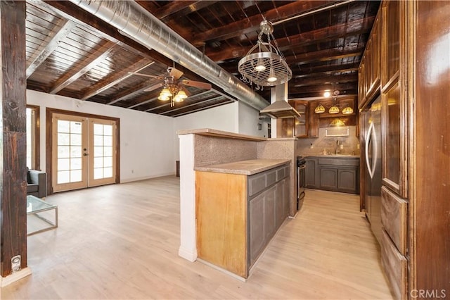 kitchen featuring beam ceiling, light hardwood / wood-style flooring, french doors, and range hood