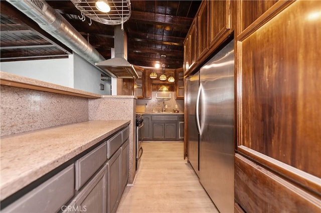 kitchen featuring tasteful backsplash, stainless steel appliances, exhaust hood, sink, and light hardwood / wood-style floors