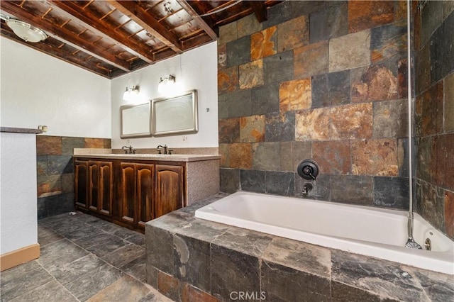 bathroom featuring wood ceiling, vanity, a relaxing tiled tub, tile walls, and beamed ceiling