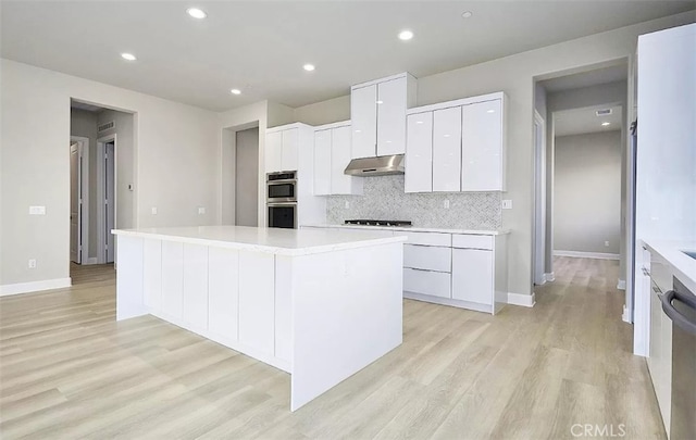 kitchen featuring light hardwood / wood-style floors, a kitchen island, and white cabinetry