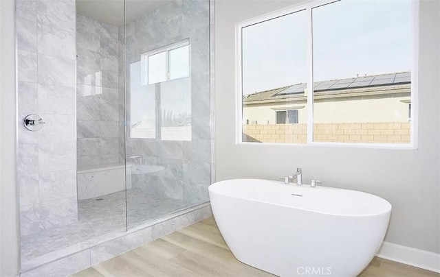 bathroom with wood-type flooring and independent shower and bath