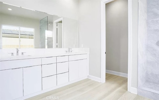 bathroom with vanity, wood-type flooring, and tiled shower