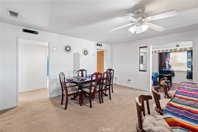 dining area featuring light carpet and ceiling fan