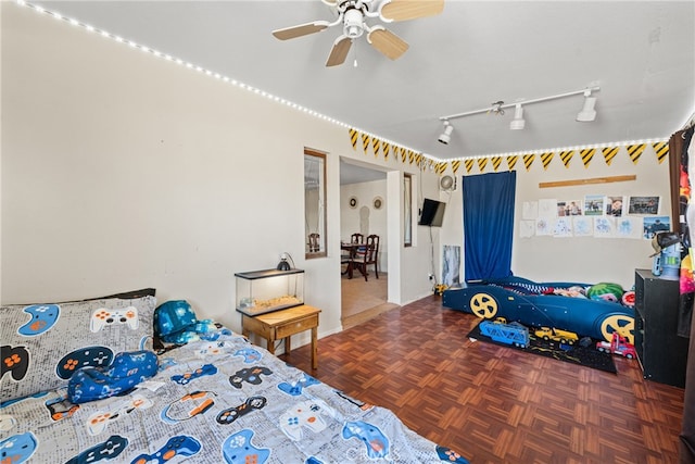 bedroom with parquet flooring, rail lighting, and ceiling fan