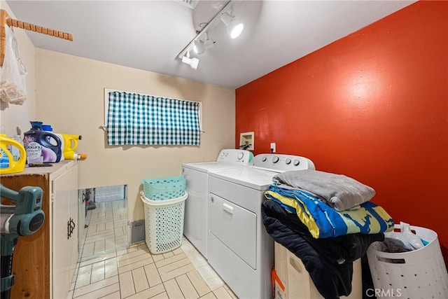 washroom featuring washing machine and dryer and rail lighting