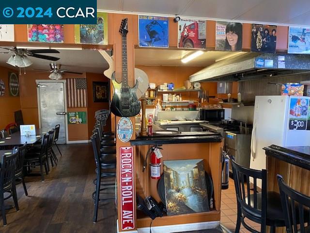 kitchen featuring ventilation hood, white fridge, ceiling fan, and hardwood / wood-style floors