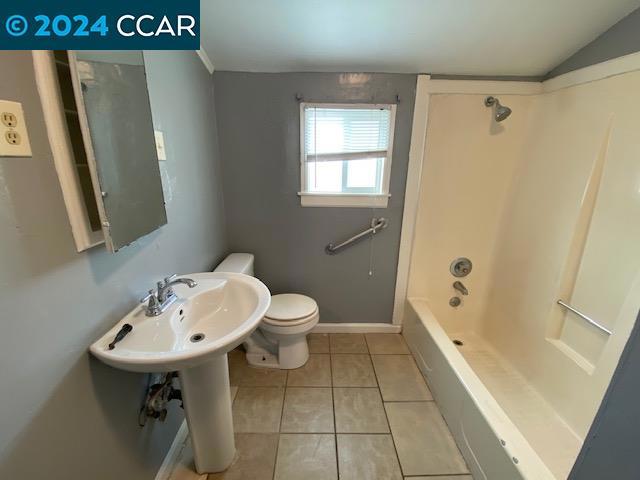 bathroom with shower / washtub combination, tile floors, and toilet