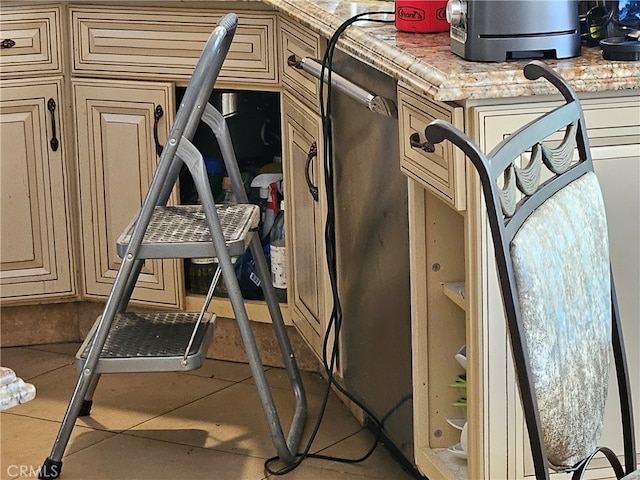 room details featuring cream cabinets and light stone counters