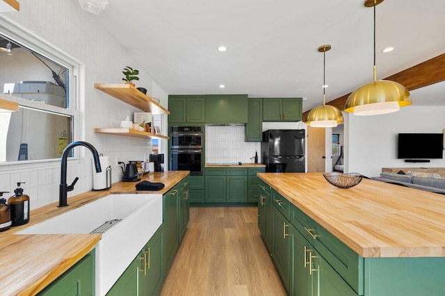 kitchen with black refrigerator, wooden counters, tasteful backsplash, and green cabinetry