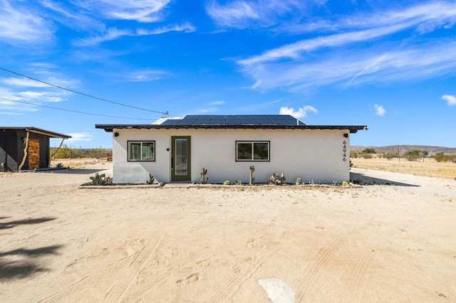 view of front of property featuring solar panels