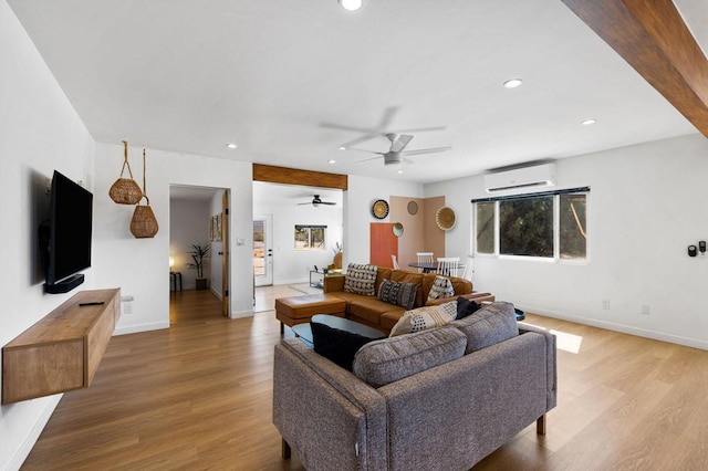 living room featuring ceiling fan, light hardwood / wood-style flooring, and a wall mounted air conditioner