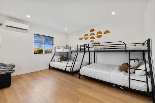 bedroom with wood-type flooring and an AC wall unit