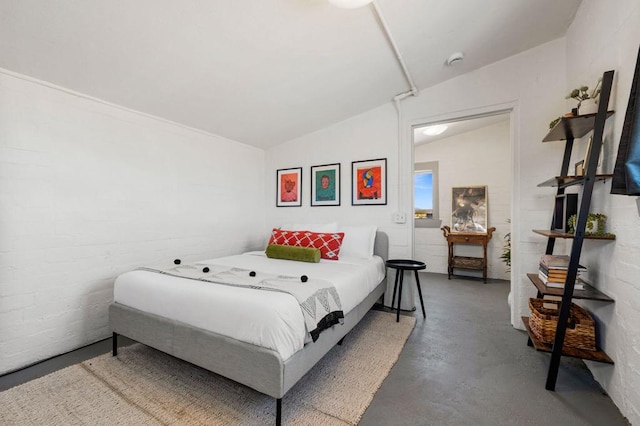 bedroom with concrete flooring and vaulted ceiling