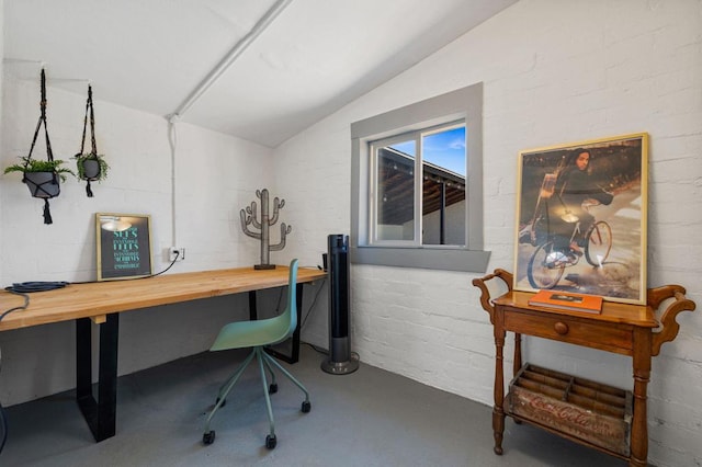 home office with lofted ceiling and concrete floors