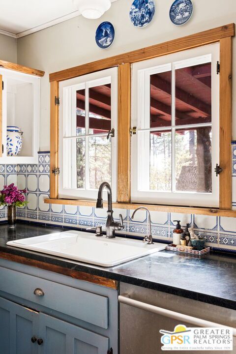 kitchen featuring sink, decorative backsplash, stainless steel dishwasher, and gray cabinets