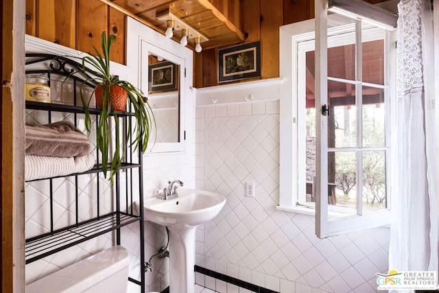 bathroom with tile walls, tile patterned flooring, plenty of natural light, and toilet