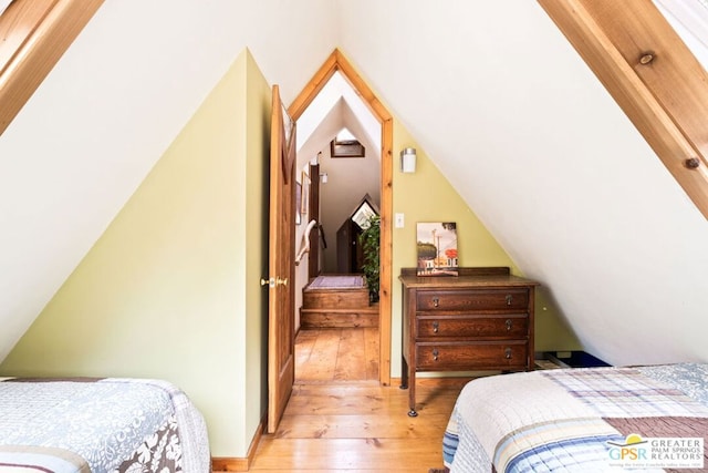 bedroom featuring light hardwood / wood-style flooring and lofted ceiling