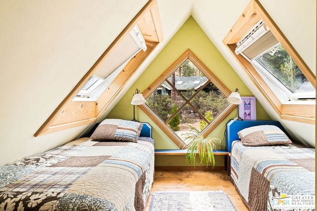 bedroom with light hardwood / wood-style flooring and a skylight