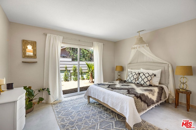 bedroom with concrete floors and access to outside