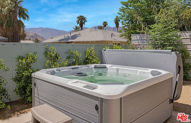 deck featuring a hot tub and a mountain view