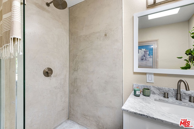 bathroom with walk in shower and vanity