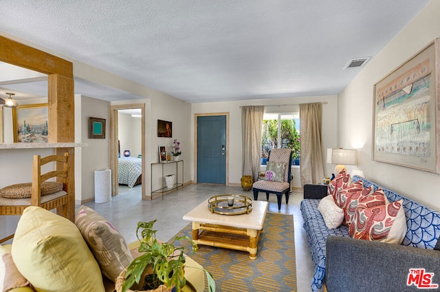 living room with a textured ceiling and concrete flooring