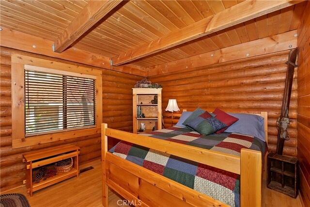 bedroom with wood-type flooring, log walls, beam ceiling, and wood ceiling