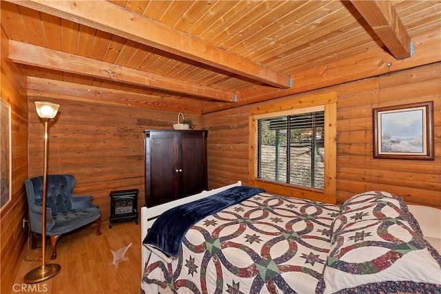 bedroom featuring hardwood / wood-style flooring, a wood stove, beamed ceiling, and wooden ceiling