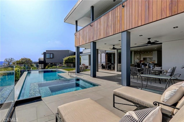 view of swimming pool with a patio, ceiling fan, and an in ground hot tub