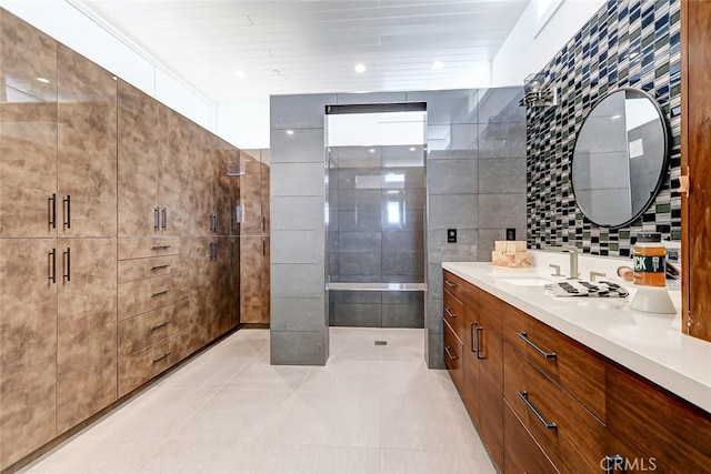 bathroom with tile walls, vanity, tile patterned floors, and a tub to relax in