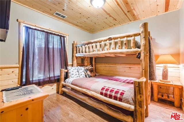 bedroom featuring light hardwood / wood-style flooring and wood ceiling