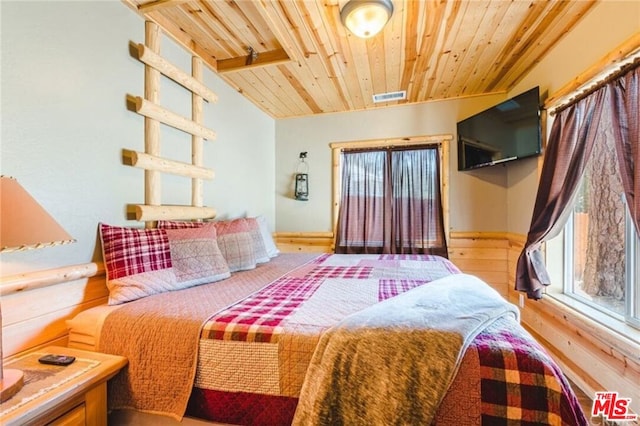 bedroom with lofted ceiling, light wood-type flooring, and wooden ceiling