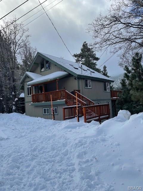 view of snowy exterior featuring a deck